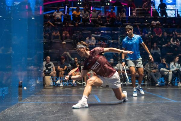 Paul Coll Superman limited edition squash shirt –  XTPro performance fabric in red on court retrieving a ball